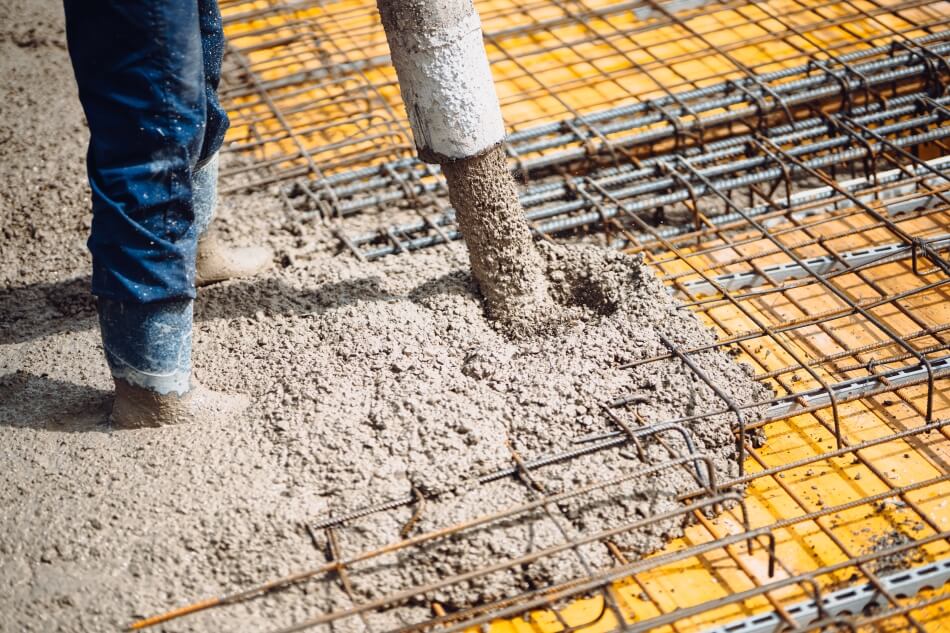 Concrete pump hire Bradford delivering fresh concrete accurately onto reinforced foundations at a construction site
