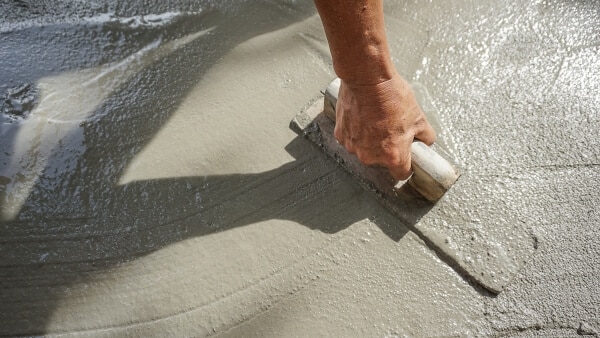 Construction worker smoothing ready mix concrete on a building site